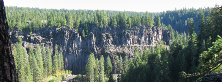 Color photo of Klickitat Canyon where sheer cliffs line the river canyon.