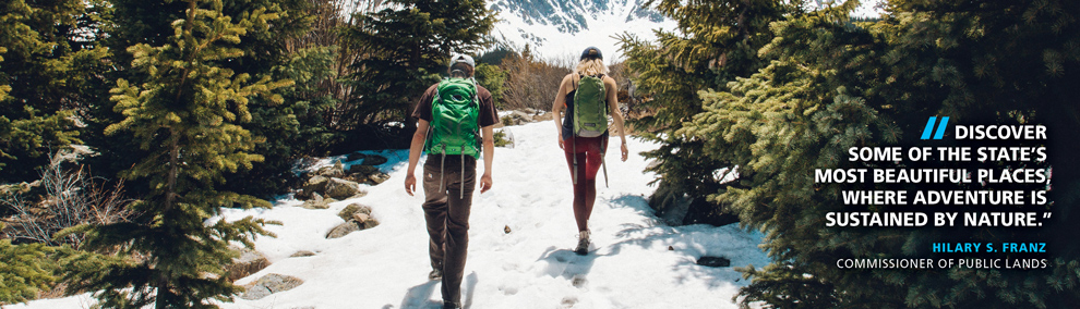 Hikers on a trail. Commissioner of Public Lands Hilary Franz quote: Discover  some of the state’s most beautiful places, where adventure is  sustained by nature.