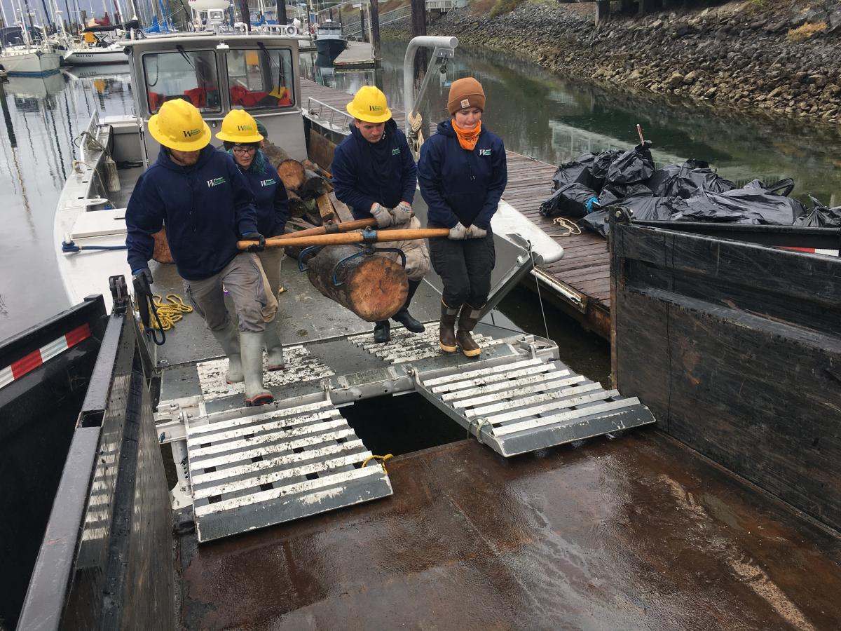 Staff carrying marine debris up ramp