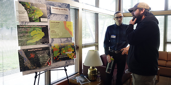 DNR employee Miles Micheletti discussing a poster at the OESF Science Conference