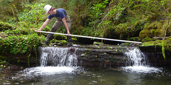 A technician measuring channel width in the OESF